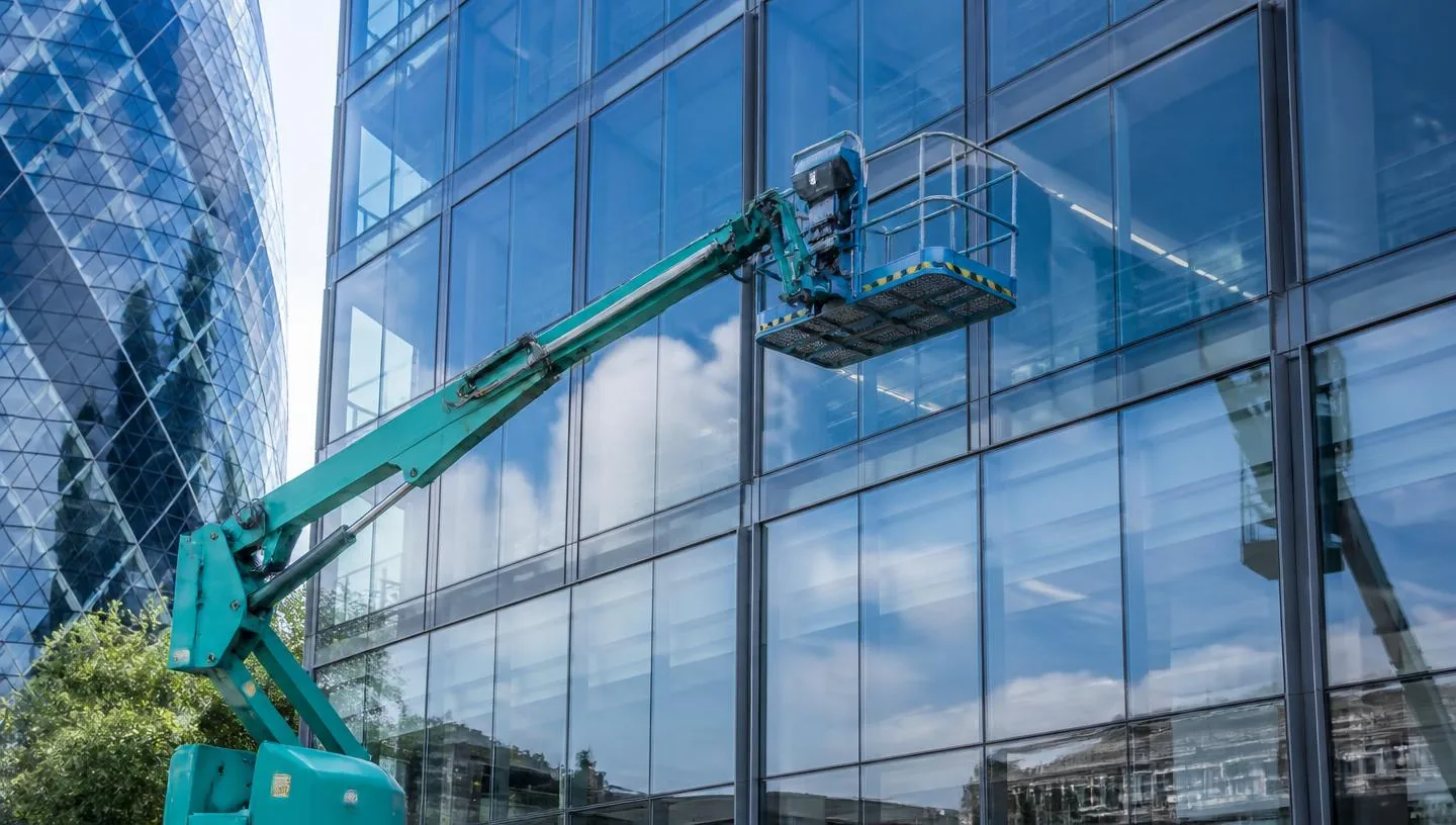 High level cleaning contractor using a boom lift to clean commercial glazing at height